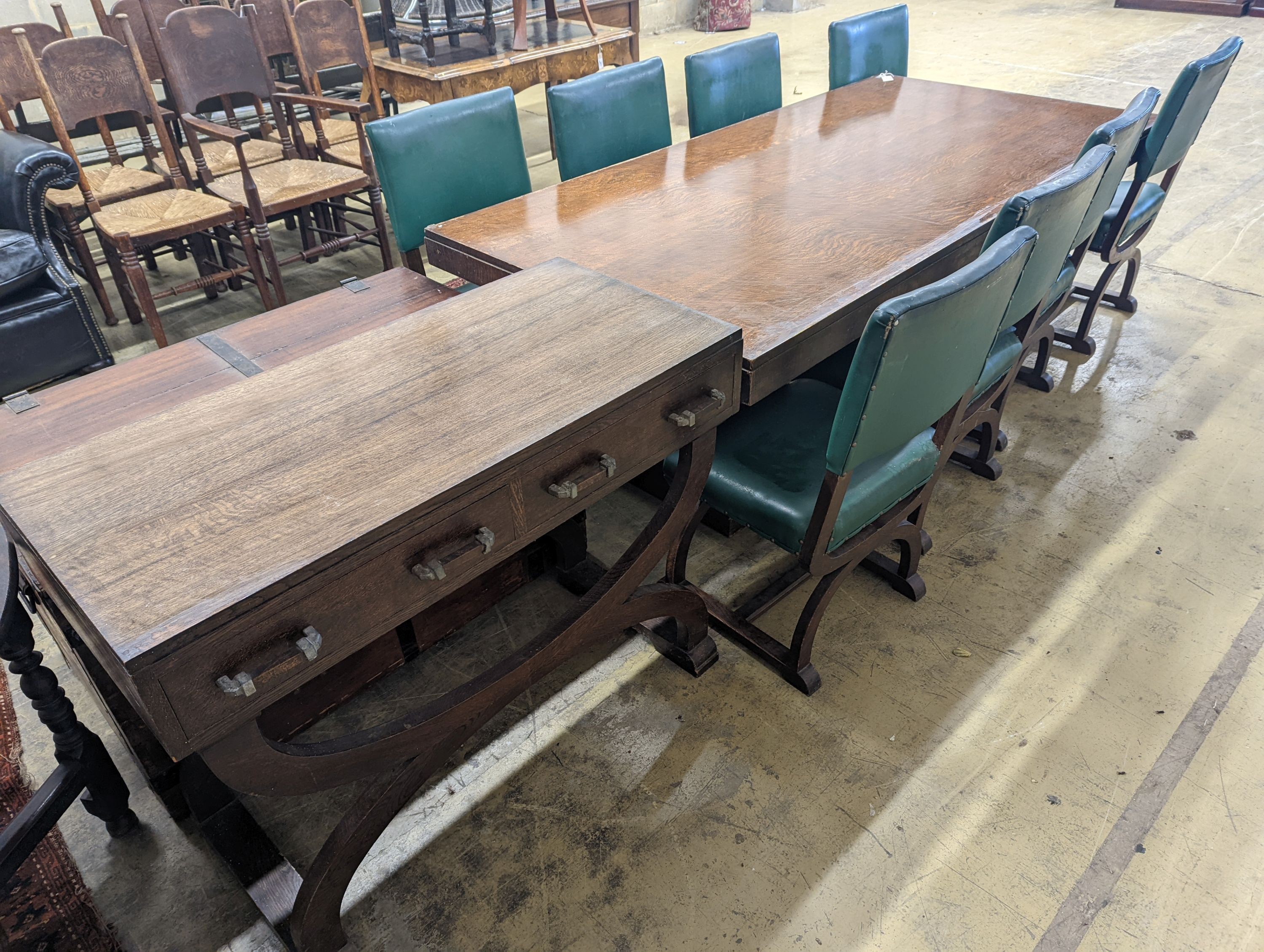 An early 20th century oak dining suite comprising rectangular table, length 216cm, width 106cm, height 74cm together with eight 'X' frame chairs and serving table